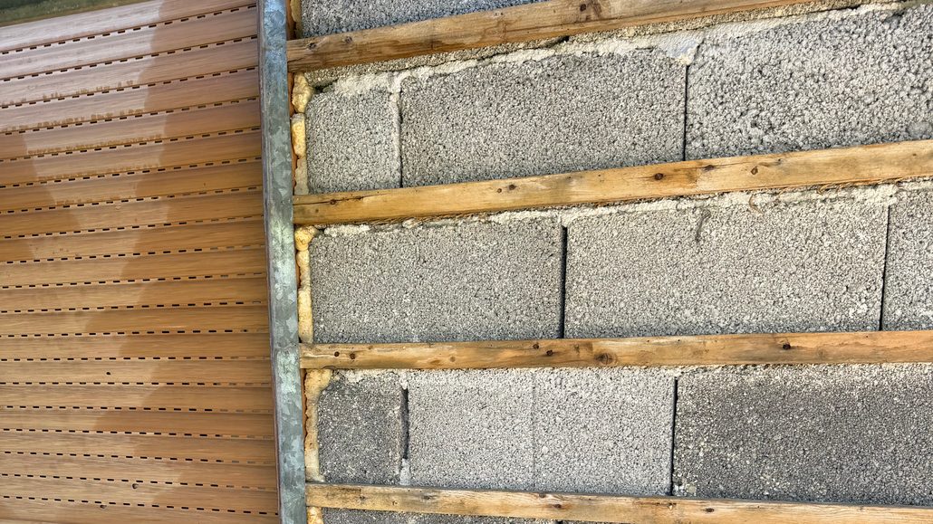Hauswand ohne Verkleidung: Mauerwerk mit alter Holzlattung neben einem Fenster mit Rollladen Hauswand ohne Verkleidung: Mauerwerk mit alter Holzlattung neben einem Fenster mit Rollladen